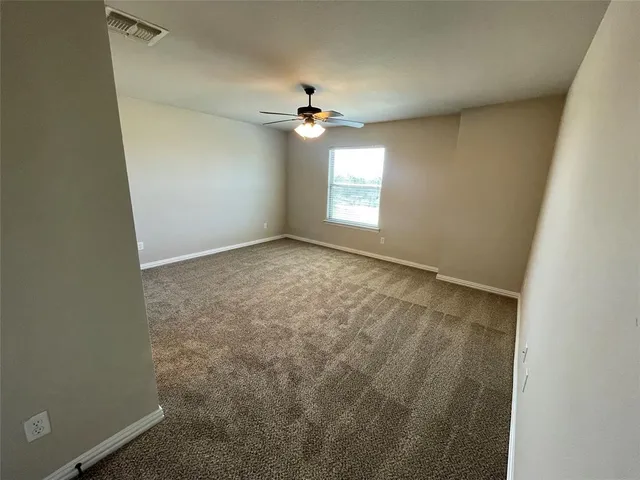 an empty room with a window and a ceiling fan