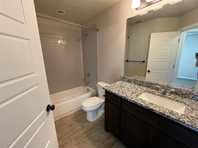 a bathroom with a granite countertop sink toilet and shower