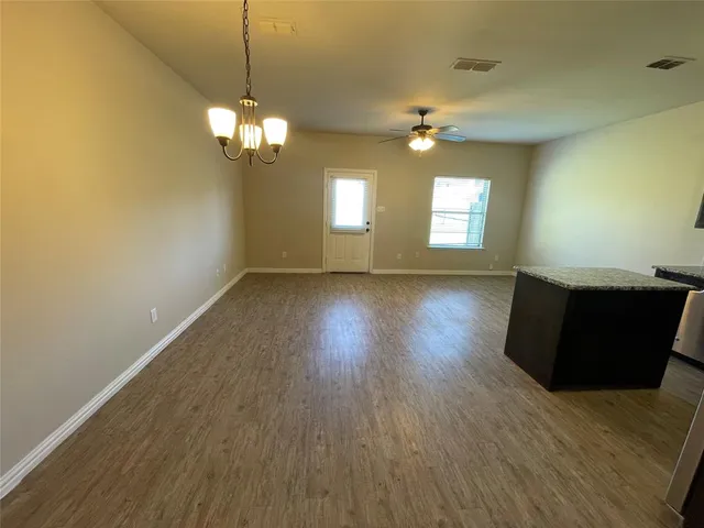 a view of a livingroom with wooden floor and a ceiling fan