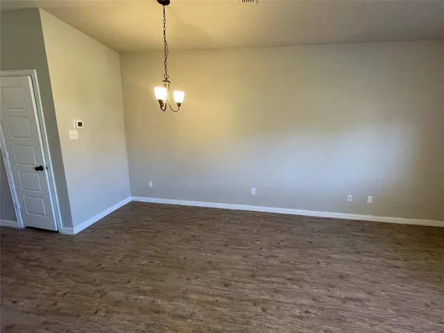 a view of a room with wooden floor and white walls