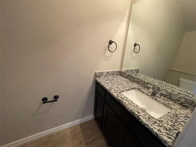 a bathroom with a granite countertop sink and vanity