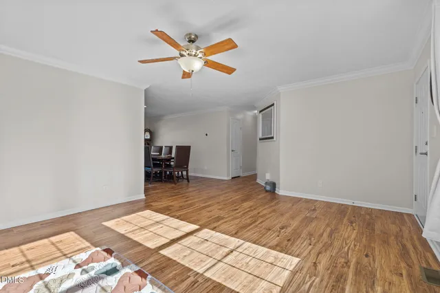 a living room with stainless steel appliances furniture a dining table and kitchen view