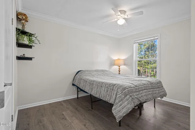 a living room with furniture a wooden floor and next to a window