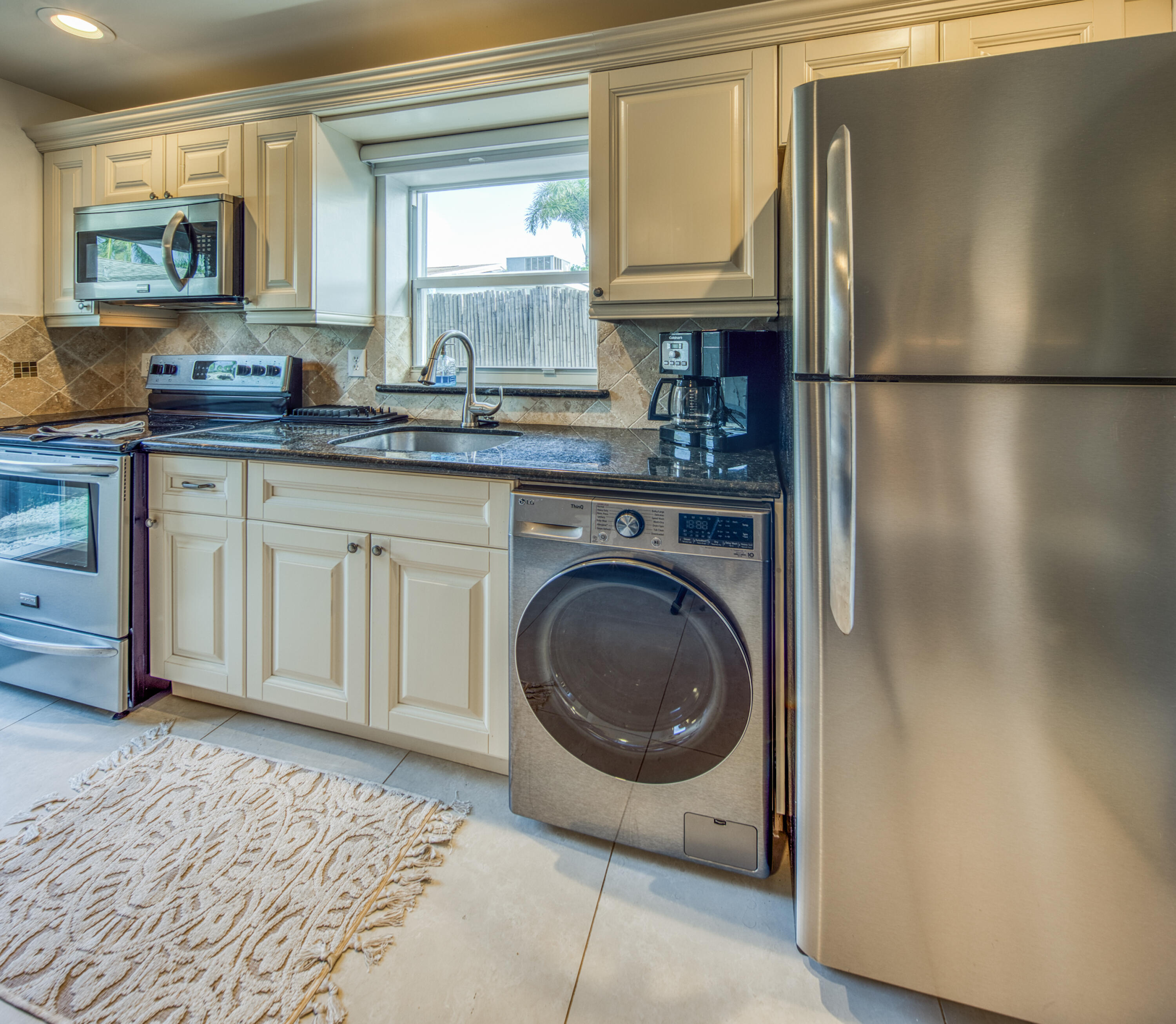 1331 North N Street, Unit GUEST HOUSE Lake Worth Beach, FL 33460 - Photo 3 of 23 a kitchen with stainless steel appliances granite countertop a refrigerator sink and stove