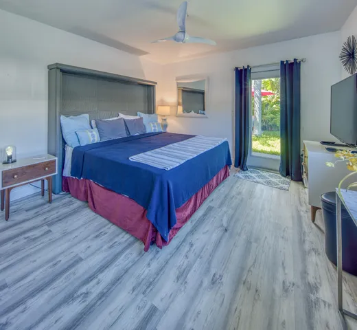 a bedroom with a bed and a flat tv screen on dresser