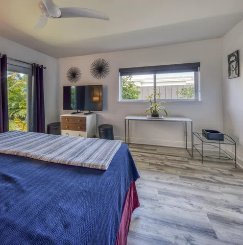 a spacious bedroom with a large bed and a flat screen tv