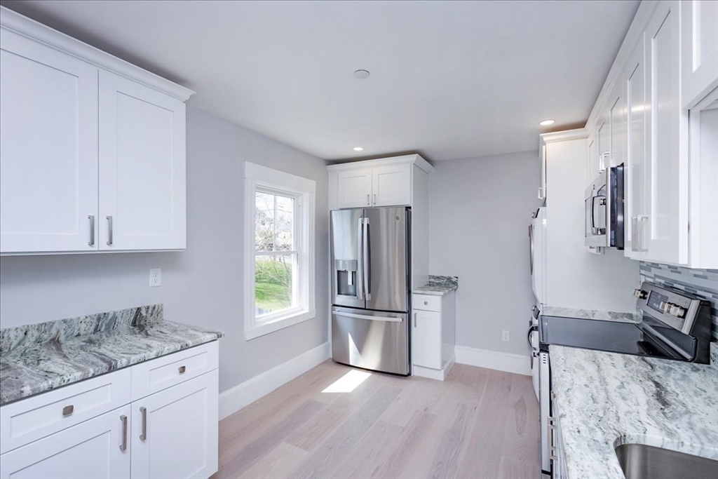 22 Berkley Road, Unit 2 Hull, MA 02045 - Photo 14 of 39 a kitchen with granite countertop a refrigerator and wooden floor