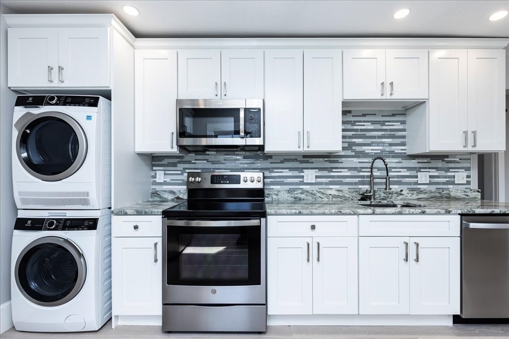 22 Berkley Road, Unit 2 Hull, MA 02045 - Photo 16 of 39 a kitchen with white cabinets and stainless steel appliances