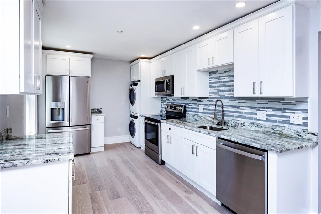 22 Berkley Road, Unit 2 Hull, MA 02045 - Photo 18 of 39 a kitchen with stainless steel appliances white cabinets a sink a stove a refrigerator and a microwave