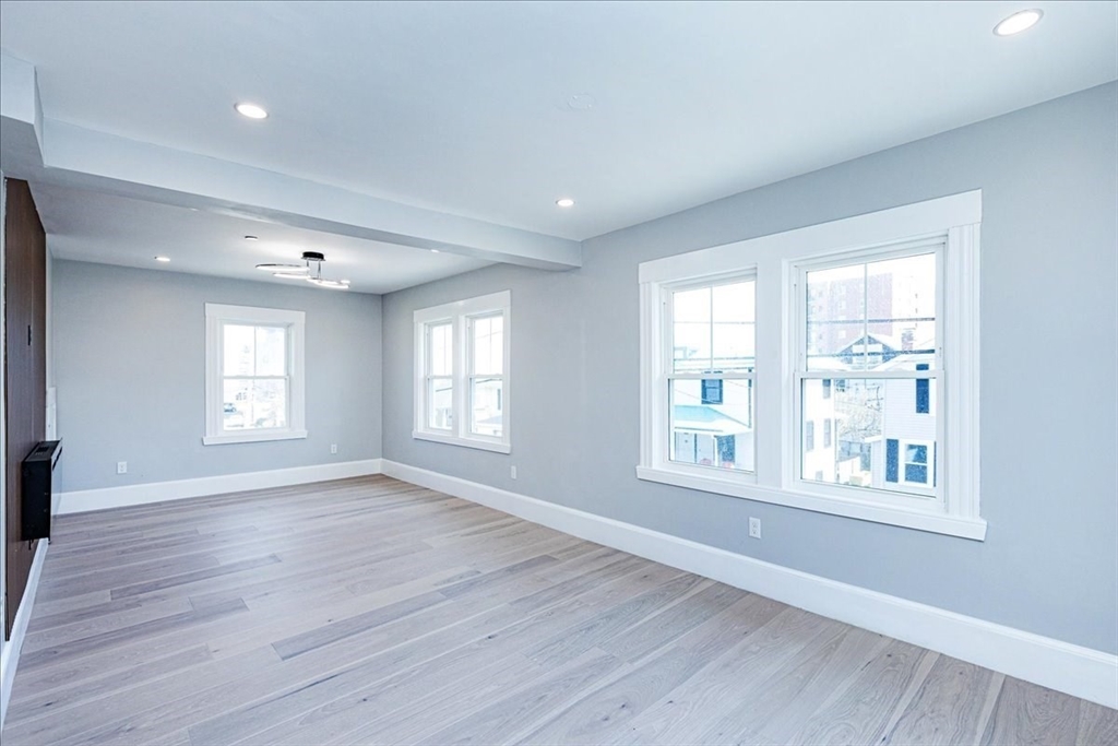 22 Berkley Road, Unit 2 Hull, MA 02045 - Photo 23 of 39 a view of an empty room with wooden floor and a window