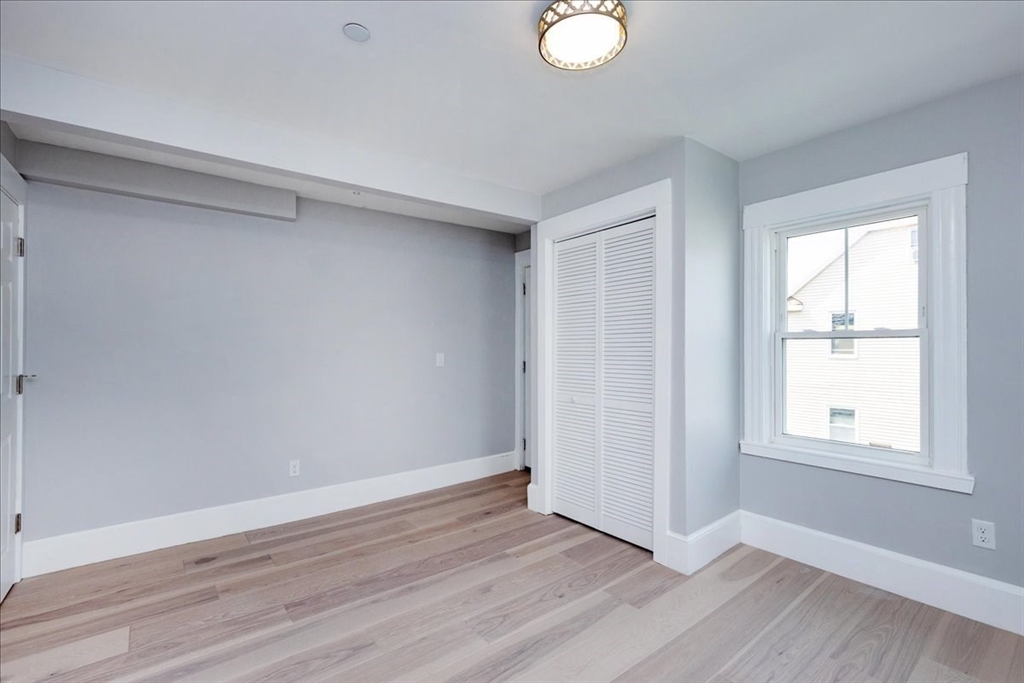 22 Berkley Road, Unit 2 Hull, MA 02045 - Photo 25 of 39 an empty room with wooden floor and windows