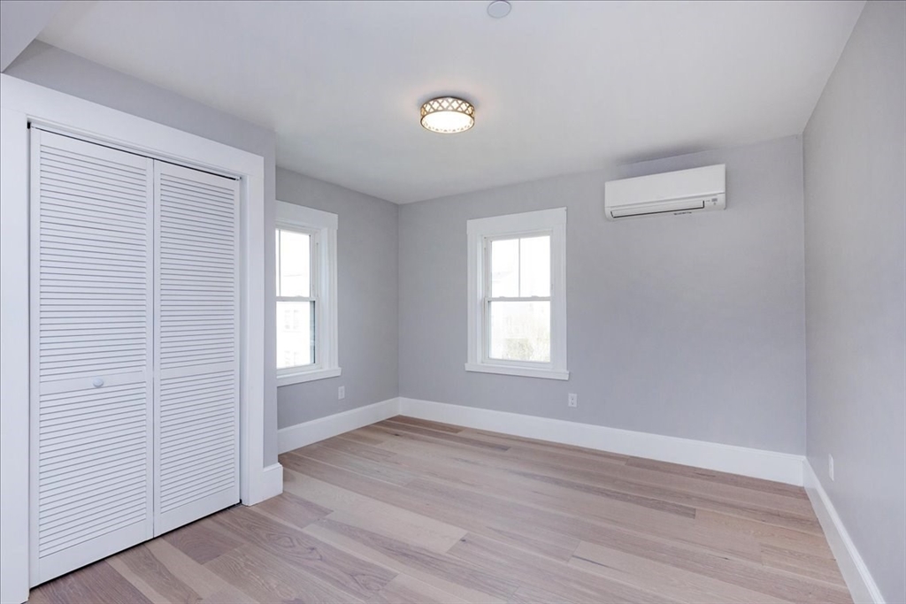 22 Berkley Road, Unit 2 Hull, MA 02045 - Photo 26 of 39 an empty room with wooden floor and windows