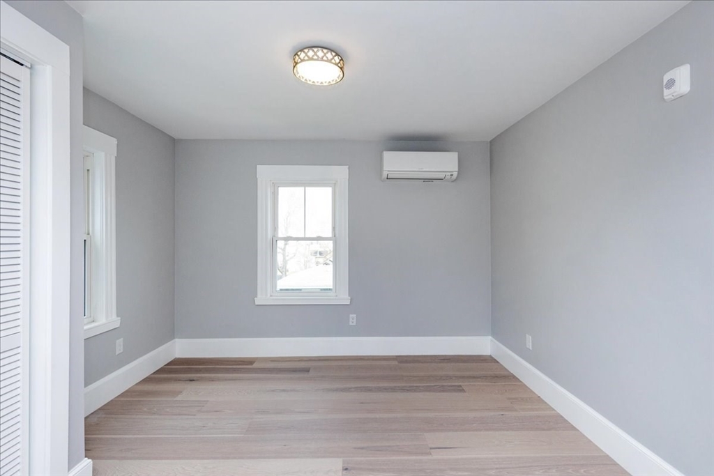 22 Berkley Road, Unit 2 Hull, MA 02045 - Photo 27 of 39 an empty room with wooden floor and windows