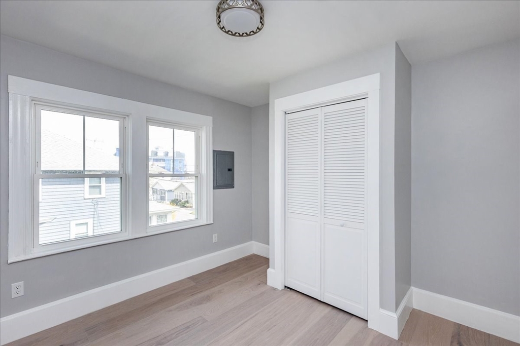 22 Berkley Road, Unit 2 Hull, MA 02045 - Photo 29 of 39 an empty room with wooden floor and windows