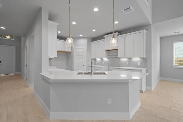 a large kitchen with kitchen island a sink stainless steel appliances and cabinets