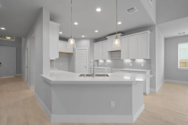 a large kitchen with kitchen island a sink stainless steel appliances and cabinets