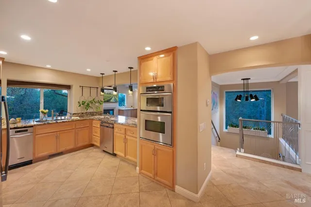 a kitchen with stainless steel appliances granite countertop a refrigerator and a sink