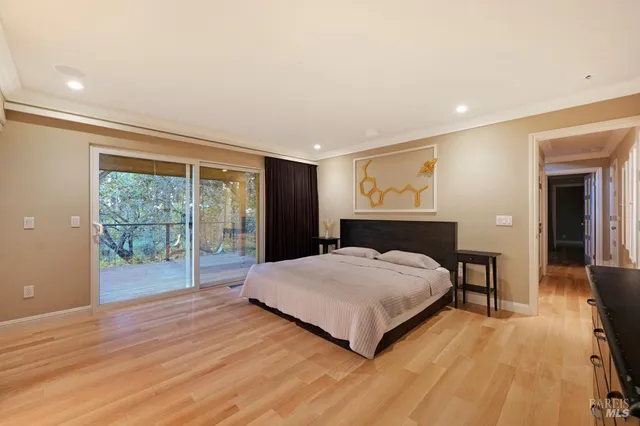 a spacious bedroom with a large bed and wooden floor