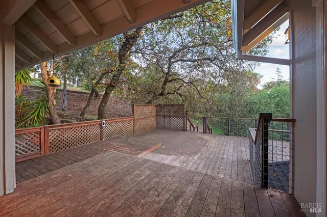 a view of backyard with wooden floor and iron fence