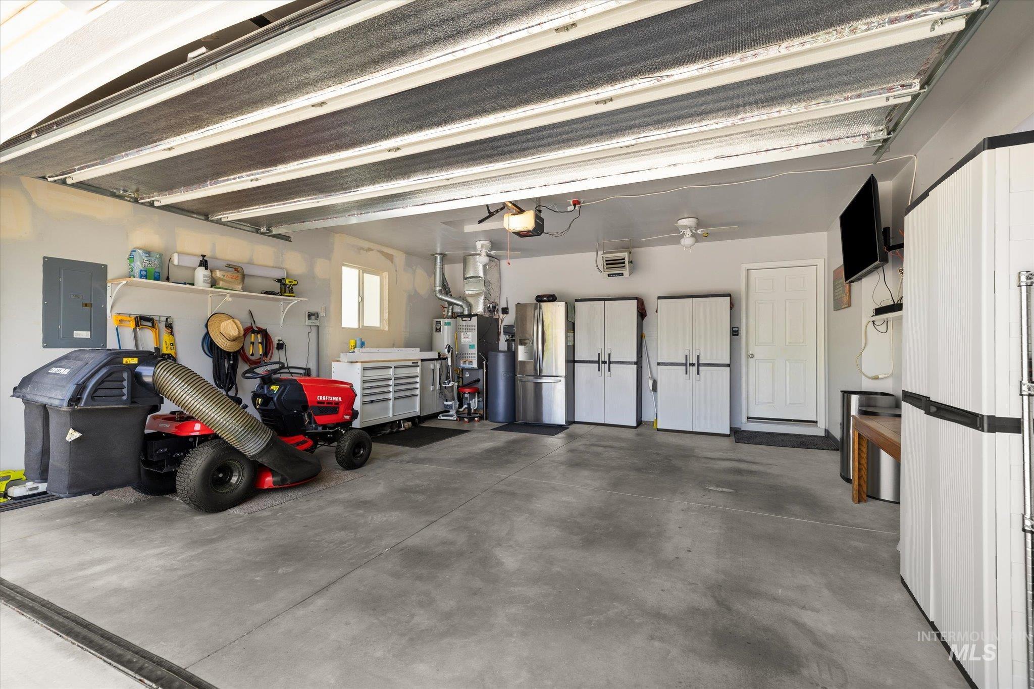 5401 Barkley Way Caldwell, ID 83607 - Photo 35 of 35 Spacious garage featuring a concrete floor, built-in storage cabinets, utility sink, and wall-mounted shelving