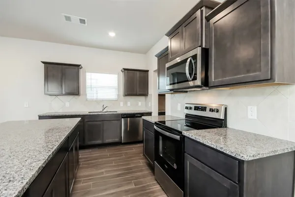 a kitchen with granite countertop stainless steel appliances and wooden cabinets