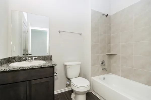 a bathroom with a granite countertop toilet a sink and bathtub