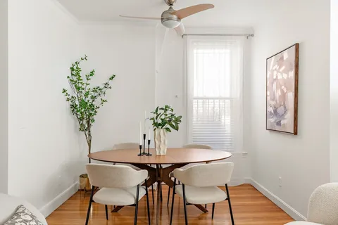 a dining room with furniture and wooden floor