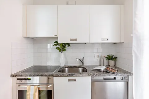 a kitchen with a stove and white cabinets