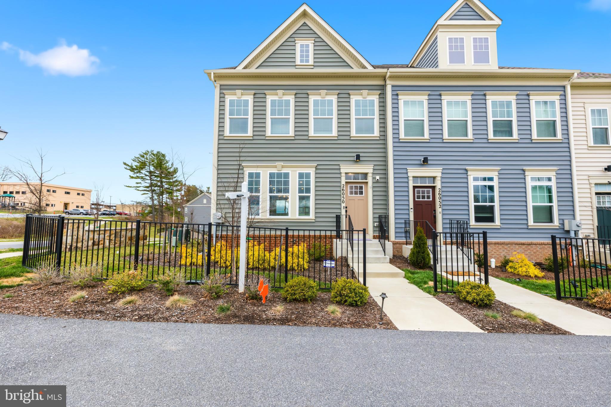 a front view of a house with a yard and potted plants