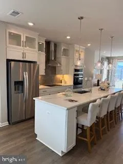 a kitchen with stainless steel appliances granite countertop a table chairs refrigerator and sink
