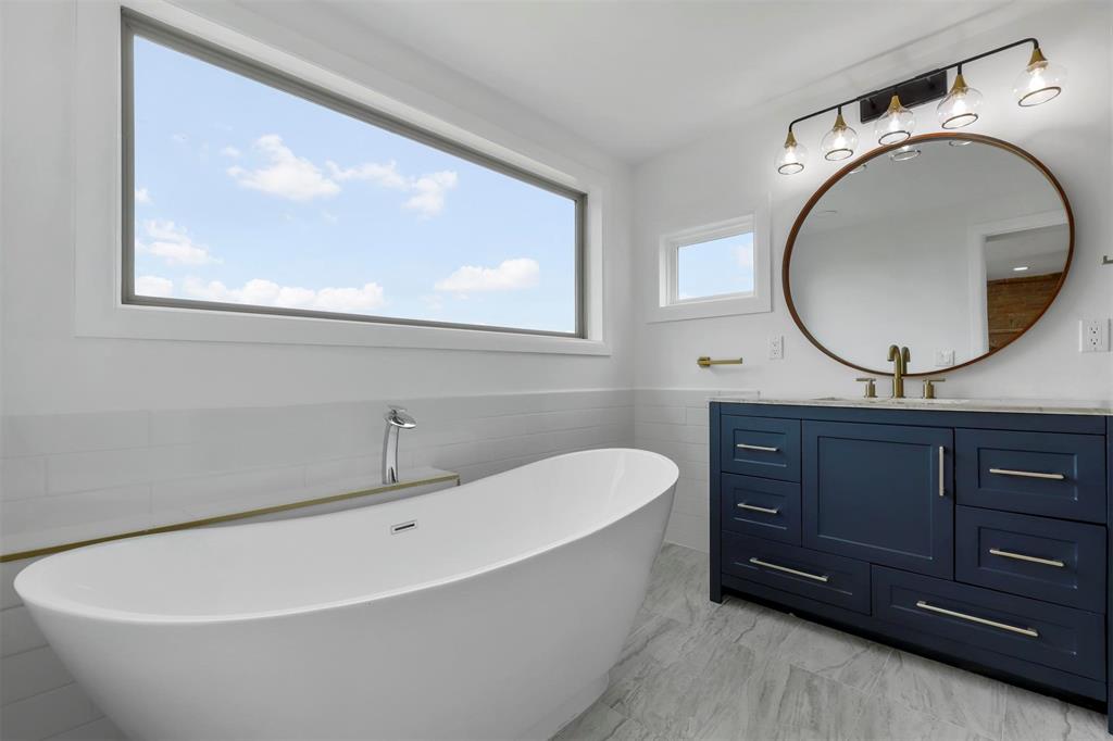 8048 Woodvale Road Fort Worth, TX 76135 - Photo 16 of 27 Bathroom featuring vanity, a washtub, tile patterned flooring, and tile walls