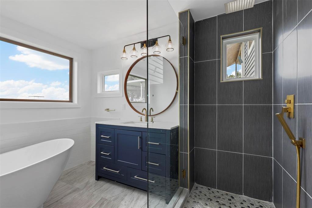 8048 Woodvale Road Fort Worth, TX 76135 - Photo 17 of 27 Bathroom with tile patterned flooring, tile walls, independent shower and bath, and vanity