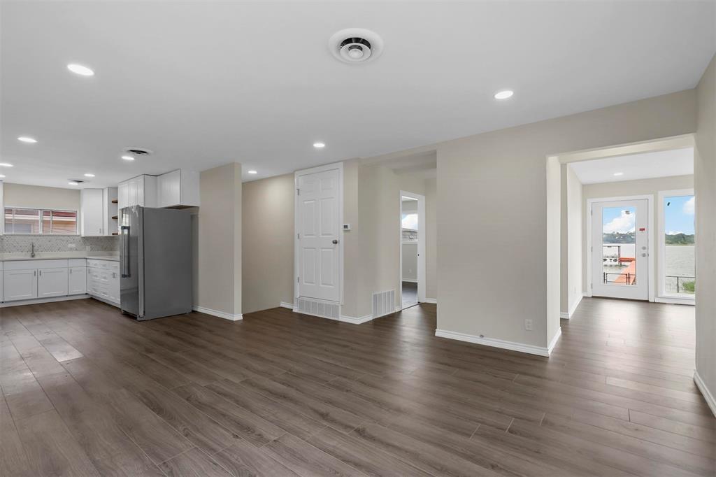 8048 Woodvale Road Fort Worth, TX 76135 - Photo 20 of 27 Unfurnished living room featuring dark wood-type flooring, sink, and plenty of natural light