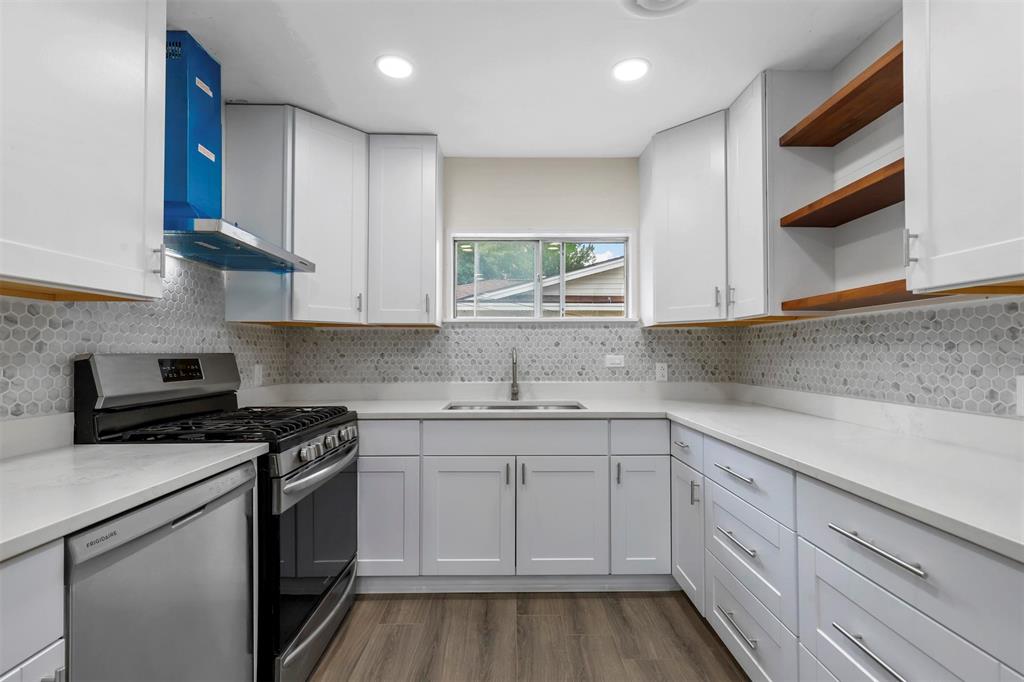8048 Woodvale Road Fort Worth, TX 76135 - Photo 25 of 27 Kitchen with sink, gas range oven, backsplash, and wall chimney exhaust hood