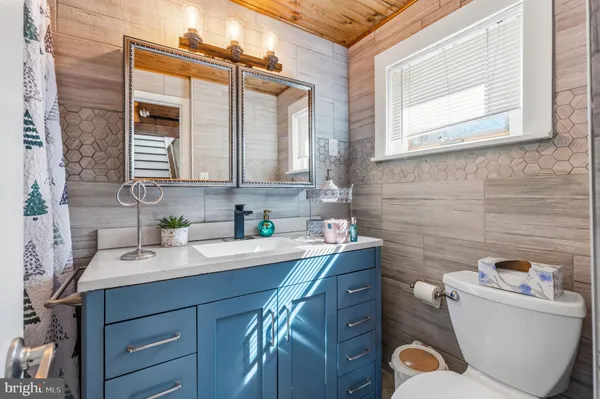 a bathroom with a granite countertop toilet sink and mirror