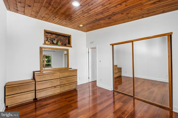 a view of a hallway with wooden floor and cabinet