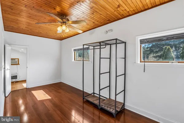 a view of a room with wooden floor and a ceiling fan