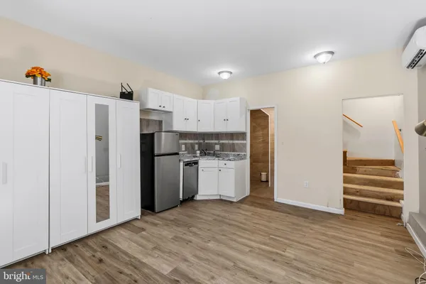 a kitchen with stainless steel appliances white cabinets and wooden floor