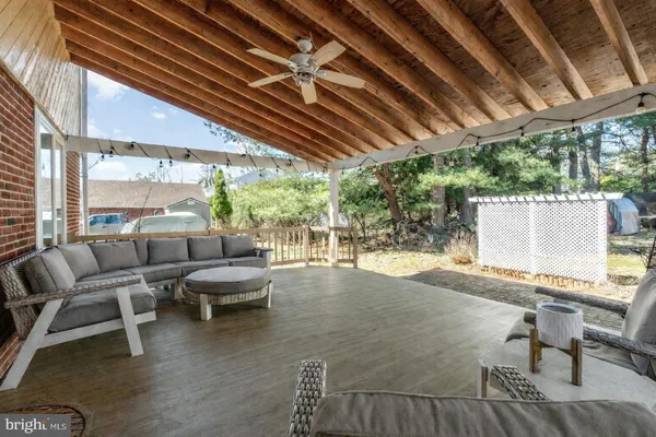 a view of a patio with table and chairs and couches with wooden floor and fence