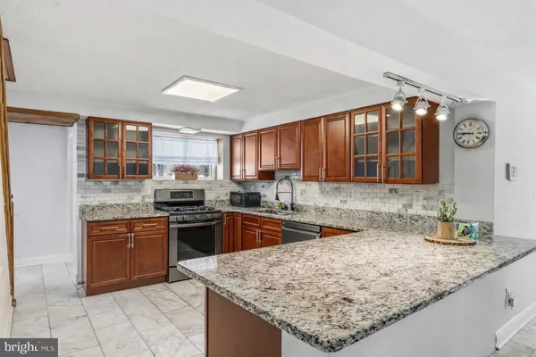 a kitchen with stainless steel appliances granite countertop a sink stove and cabinets