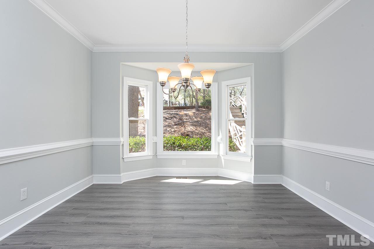 6830 Gloucester Road Raleigh, NC 27612 - Photo 12 of 28 a view of an empty room with wooden floor and a window
