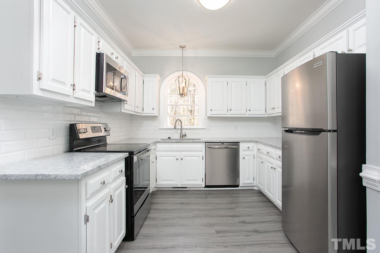 6830 Gloucester Road Raleigh, NC 27612 - Photo 3 of 28 a kitchen with stainless steel appliances granite countertop a refrigerator sink and cabinets
