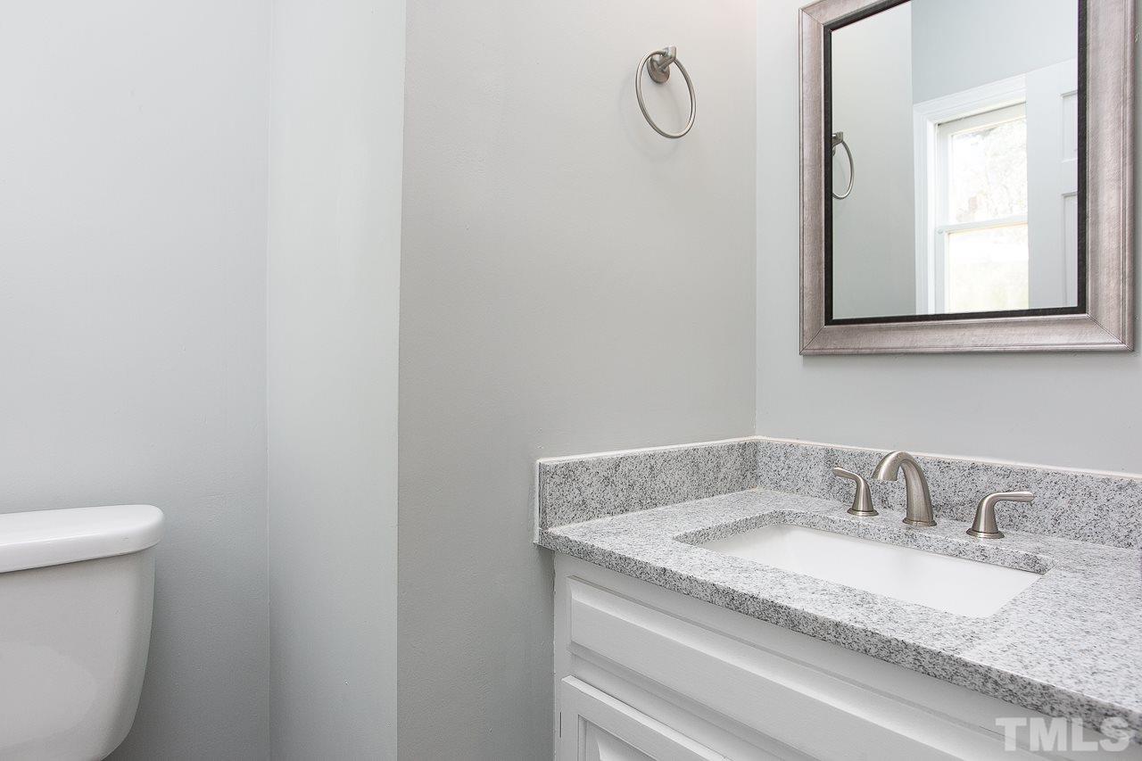 6830 Gloucester Road Raleigh, NC 27612 - Photo 24 of 28 a bathroom with a granite countertop sink and a toilet