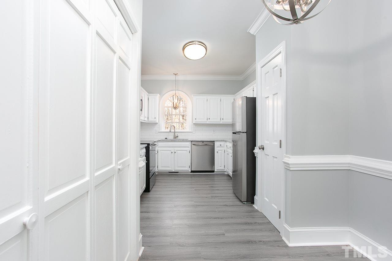 6830 Gloucester Road Raleigh, NC 27612 - Photo 6 of 28 a kitchen with white cabinets and white appliances