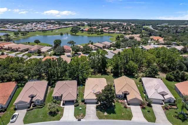 an aerial view of a residential houses with outdoor space and lake view