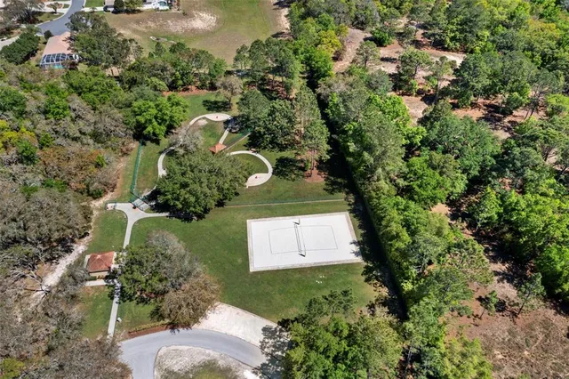 an aerial view of a house with swimming pool and tennis court
