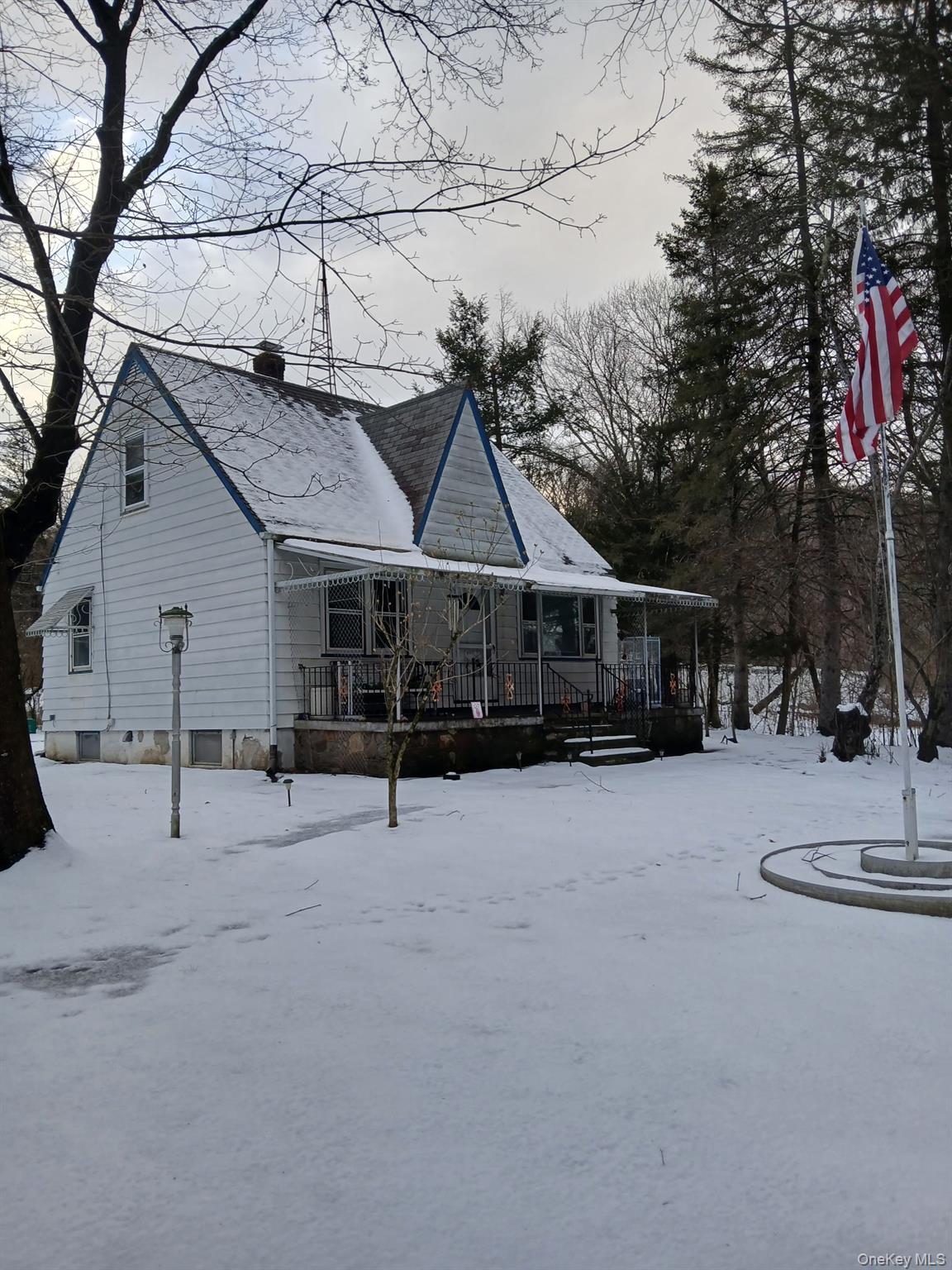 a front view of house with yard and trees in the background