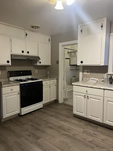 a kitchen with granite countertop a sink cabinets and stainless steel appliances