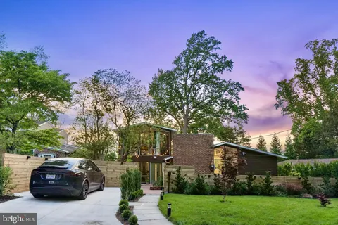 a car parked in front of a house with a yard
