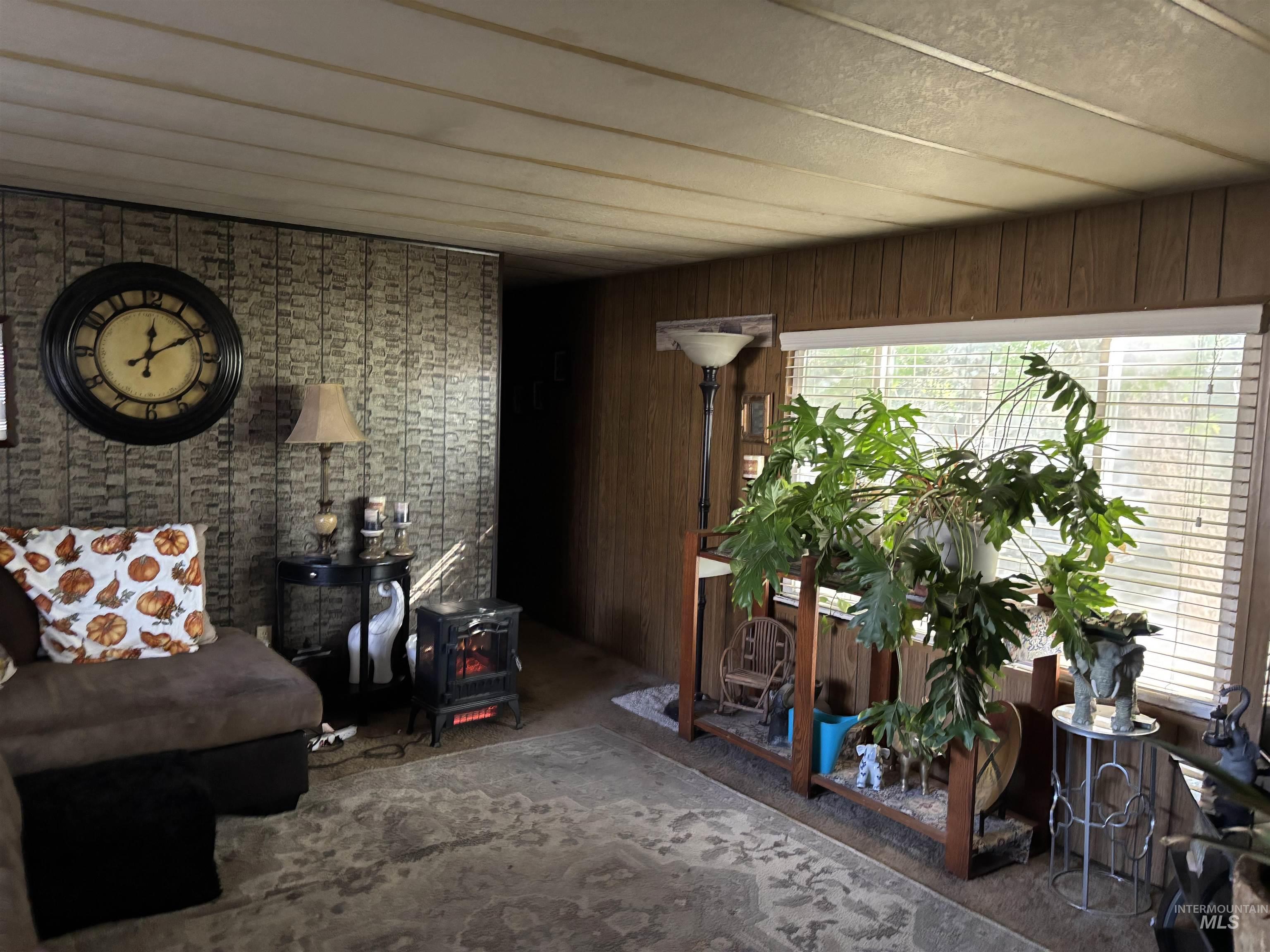 181 North Liberty Street Boise, ID 83704 - Photo 3 of 10 Sitting room with a wood stove, carpet, and wood walls